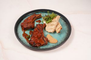 Grilled lamb rack served with rich Singapore-style Tulang Merah sauce, smooth garlic purée, fluffy Syrian hummus and sourdough bread to soak up all the flavours